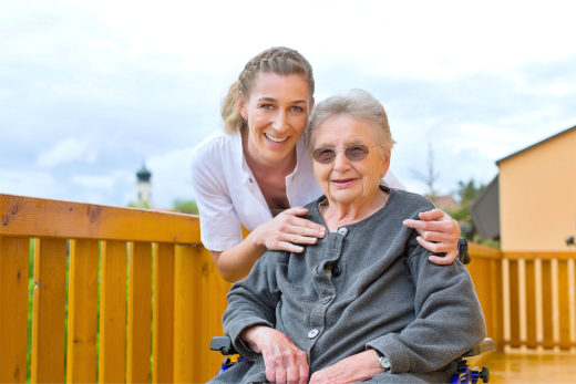 Young woman taking picture with old woman who sitting in the wheel chair